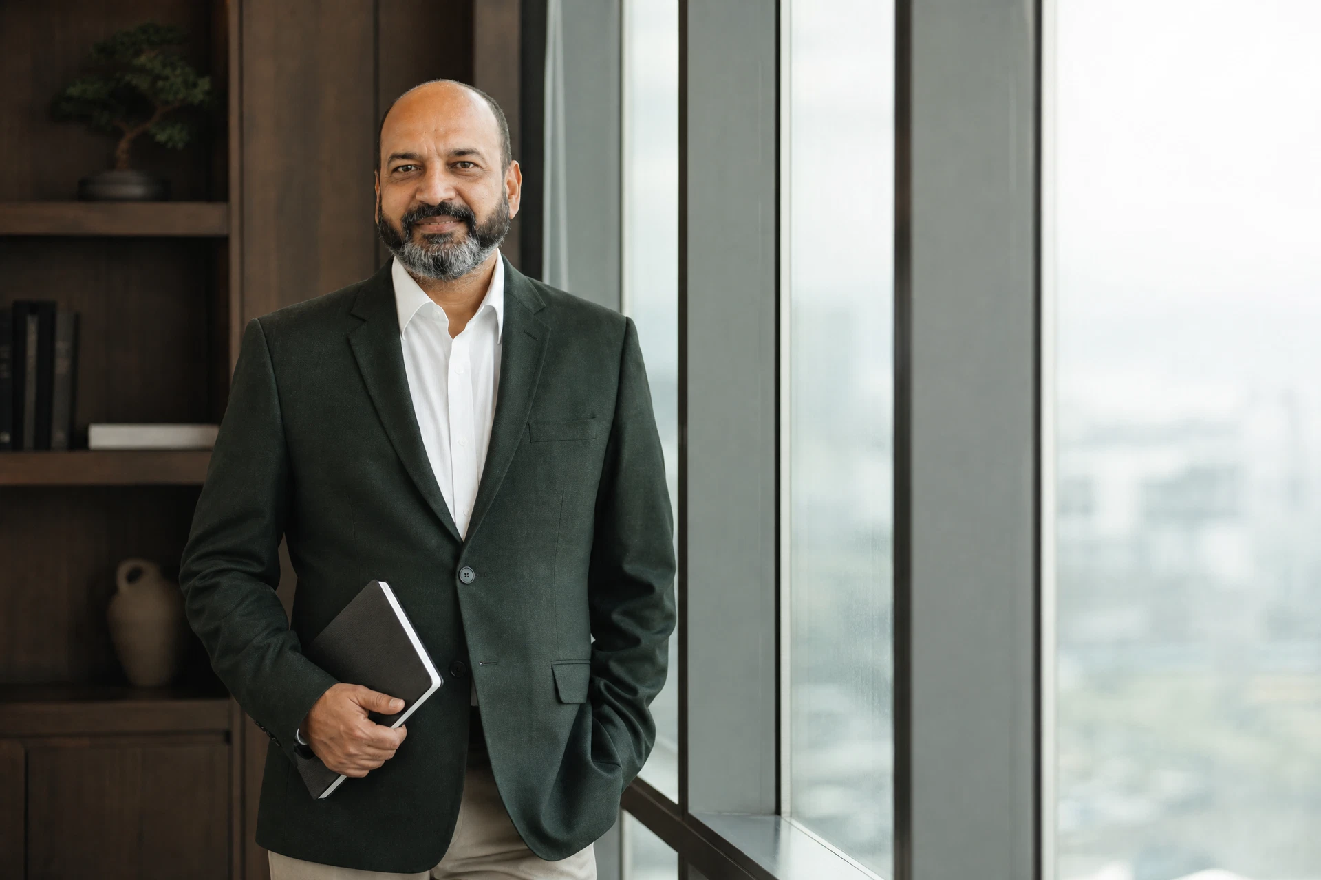 Sanjiv Agarwal standing in a modern office with a notebook